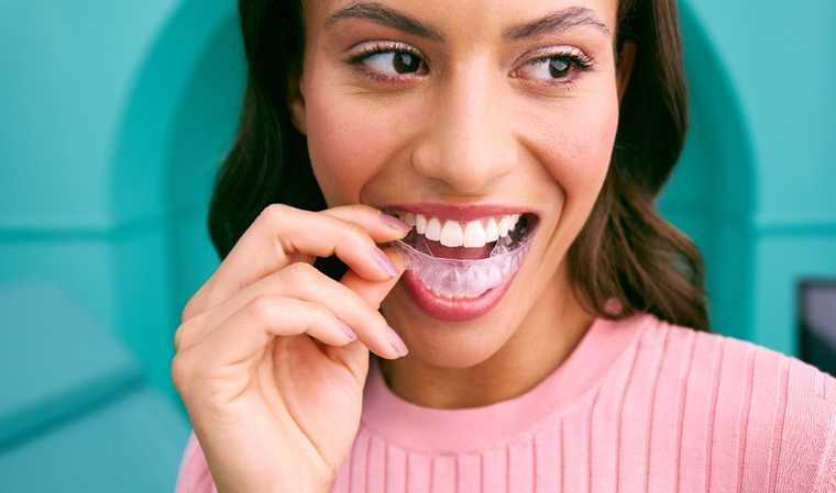 [CRO] Woman - Brunette - Smile - Aligner - Pink - Shirt - Blue - Background - Desktop